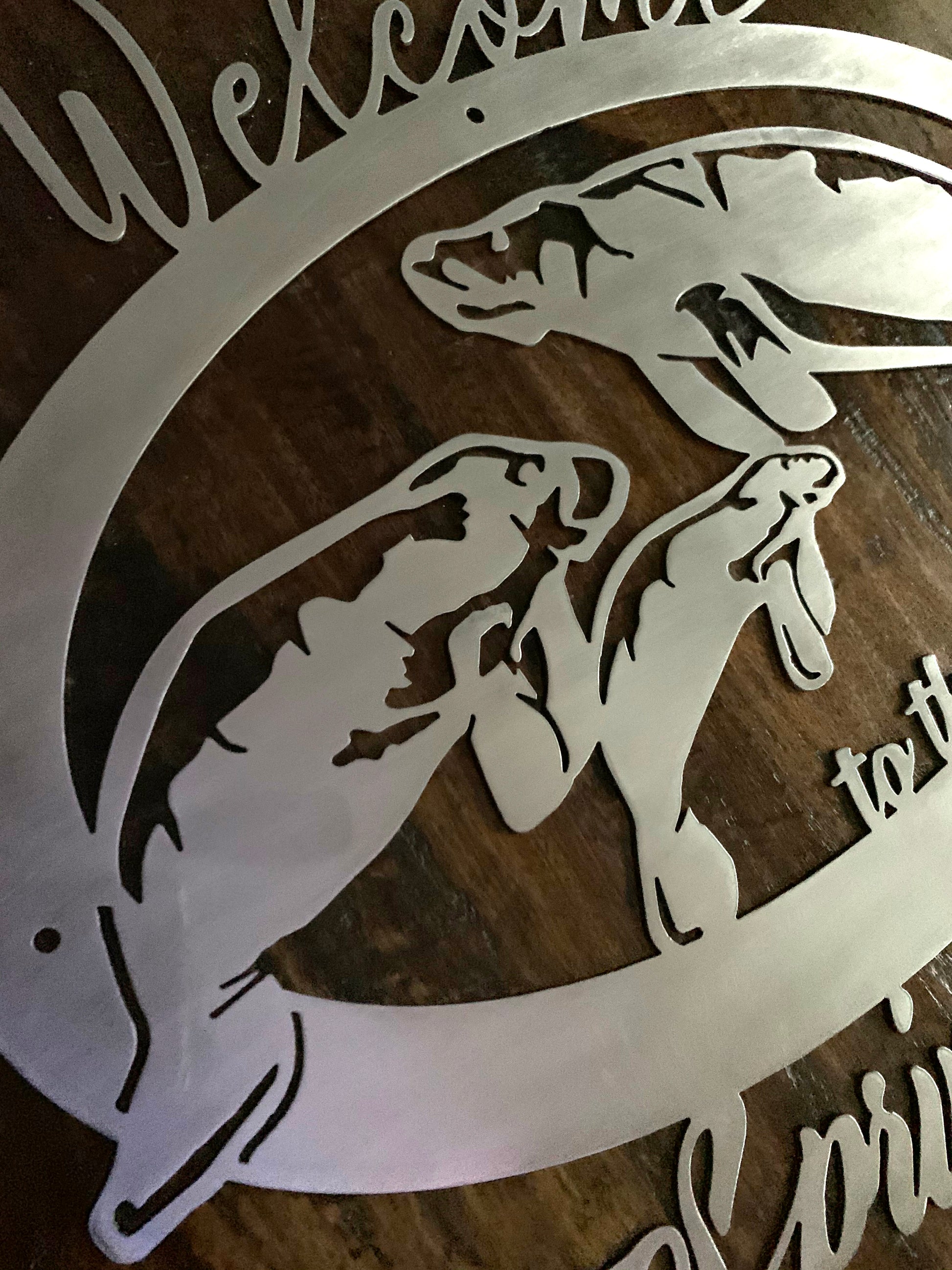 3 quarter view of 3 manatee sign in brushed metal over dark wood background