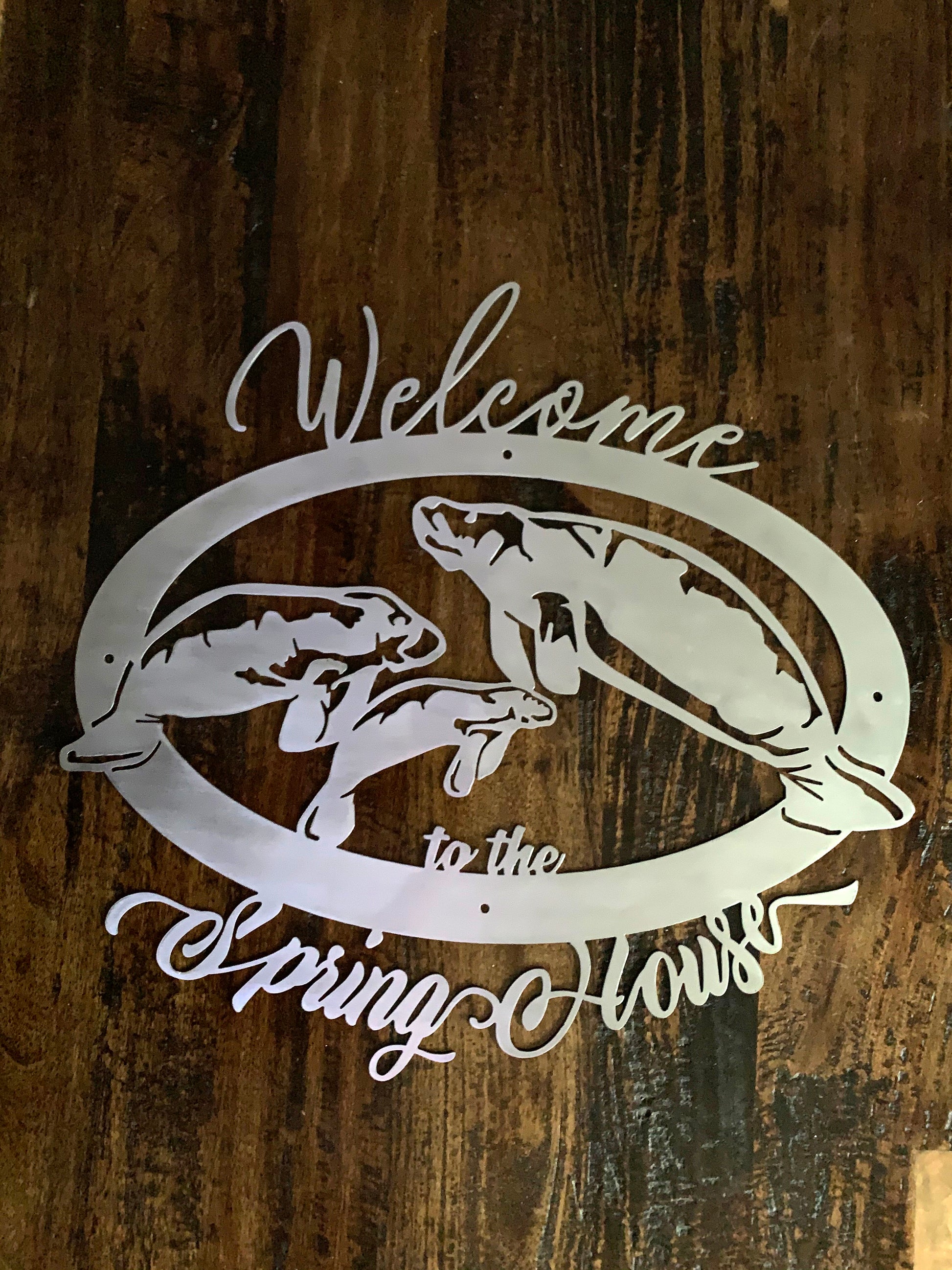 3 manatee sign in brushed metal over dark wood background